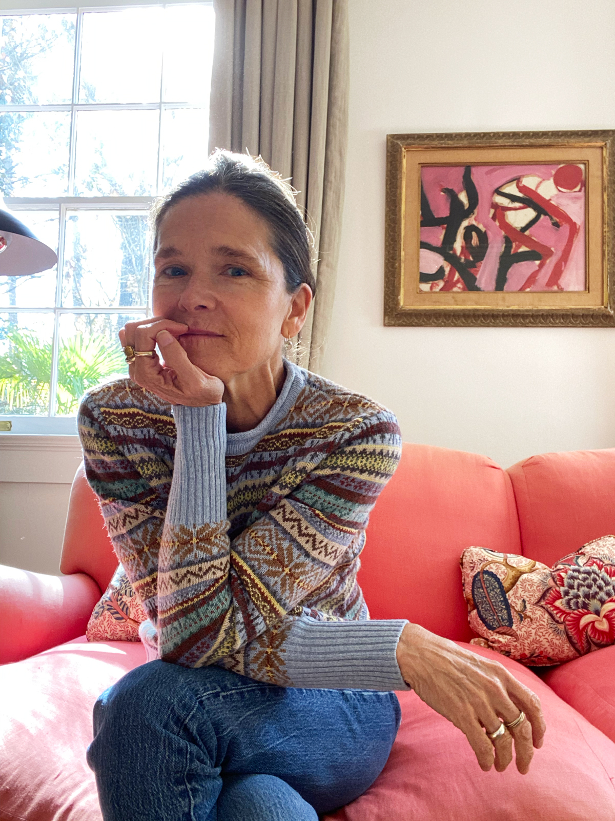 ann in a fairisle sweater and jeans on the couch